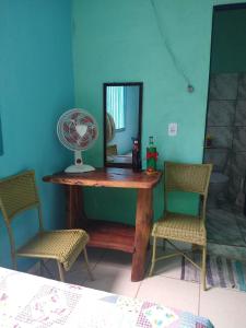 um quarto com uma mesa, uma ventoinha e 2 cadeiras em Pousada Joao & Maria em Pirenópolis