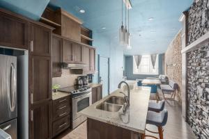 een keuken met een spoelbak en een fornuis bovenste oven bij Boutique Lofts Notre Dame - Vieux Montréal in Montreal +40 foto's