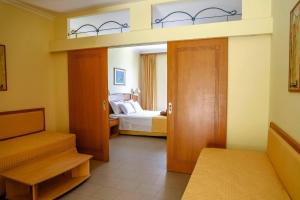 a room with a bedroom with a bed and a closet at Coloma Apartments Pefkos in Pefki