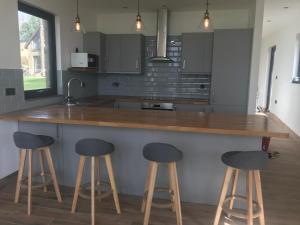 a kitchen with two bar stools at a counter at The Stables near Glasgow in Balmore