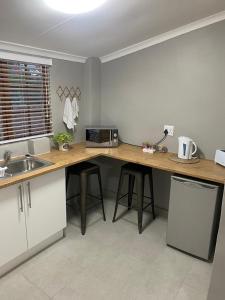 a kitchen with a counter with a microwave and a sink at Rest at Lieben in Bloemfontein