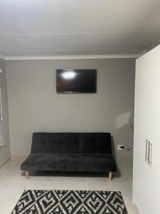 a black couch in a room with a wall at Rest at Lieben in Bloemfontein