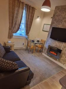 a living room with a couch and a fireplace at Carlisle City Centre, Cute Victorian House. in Carlisle