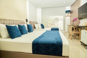 Cette chambre comprend un grand lit avec des oreillers bleus. dans l'établissement Solev Hotel, à Villavicencio