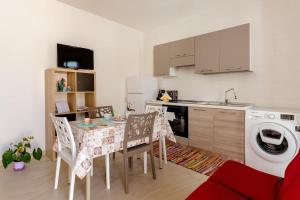 a kitchen with a table and chairs and a washing machine at Casa Vacanze La Primitiva in Manduria
