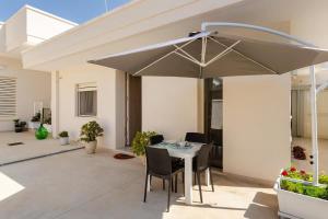 a patio with a table and chairs and an umbrella at Casa Vacanze La Primitiva in Manduria