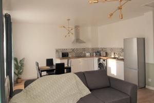 a living room with a couch and a kitchen at Les Nuits Bonneuilloises Le Henson in Breteuil