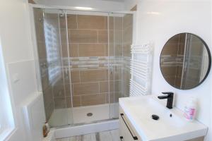 a bathroom with a shower with a sink and a mirror at Les Nuits Bonneuilloises Le Henson in Breteuil