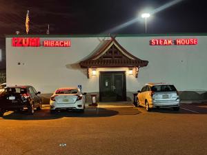 tres autos estacionados fuera de un restaurante de carne por la noche en The Wayne Inn, en Wayne