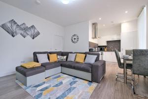 a living room with a couch and a kitchen at 5* Luxury 1 Bedroom Apartment in City Centre in Aberdeen