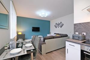 a kitchen and living room with a table and a couch at 5* Luxury 1 Bedroom Apartment in City Centre in Aberdeen +13 photos