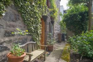 a wooden bench sitting next to a building with plants at 5* Luxury 1 Bedroom Apartment in City Centre in Aberdeen