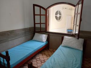 阿拉亚尔-杜卡布Acomodações Araujo的有窗户的房间里有两张床