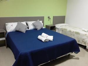 Una cama azul con dos toallas enrolladas encima. en Irundy Apartments, en Federación 50 fotos más