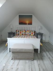 a bedroom with a white bed with pillows on it at Pier Road Cottage, Croagh Patrick in Westport