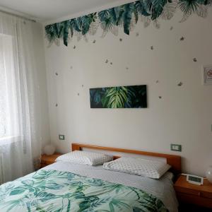 - une chambre avec un lit et une plante sur le mur dans l'établissement Rio Taglio, à Cervignano del Friuli