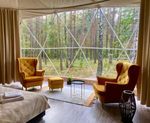 um quarto com 2 cadeiras e uma grande janela em Planeta Glamping em Zalesie Górne