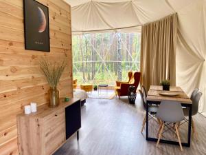 a living room with a table and a chair at Planeta Glamping in Zalesie Górne