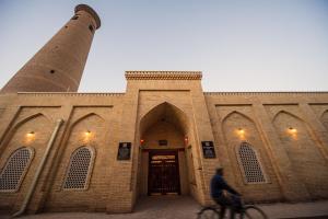 a man riding a bike in front of a building at New Star Boutique hotel - madrasah Muhammad Mahram 1903 in UNESCO World Heritage Site in Khiva