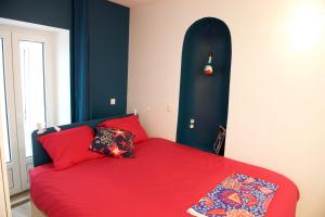 a bedroom with a red bed with a black head board at CHARMING Parisian Apartment WITH AIR CONDITIONING - CLIMATISATION & 2 BEDROOMS - Batignolles PARIS in Paris