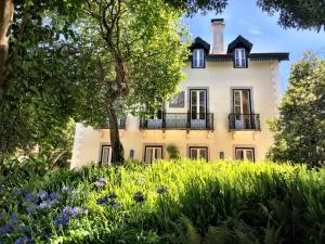 uma casa antiga com um jardim em frente em Luxurious royal estate in historic Sintra paradise em Sintra