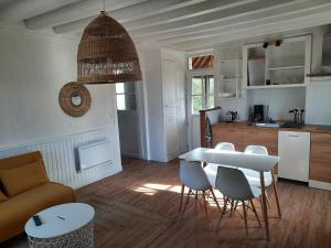 a kitchen and living room with a table and chairs at Maison avec jardin dans petit bourg typiquement Percheron - Le Colombier in Boissy-Maugis