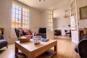 a living room with a table and a couch at LES CORDERIES in Les Sables-d'Olonne