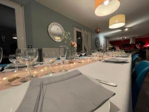 a long table with empty wine glasses on it at Gïte de l Armance in Les Ventes