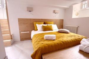 ein Schlafzimmer mit einem großen Bett und einer gelben Decke in der Unterkunft LES CORDERIES in Les Sables-dʼOlonne