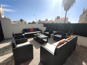 a patio with couches and chairs and a table at Vila Magna near The Strip with BBQ, AC, Balcony, Parking, 4 TVs and Free wifi in Albufeira