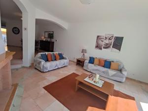 a living room with two couches and a table at Vila Magna near The Strip with BBQ, AC, Balcony, Parking, 4 TVs and Free wifi in Albufeira