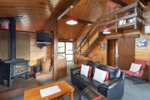a living room with leather furniture and a fireplace at Retro Inn 2 - Lake Tekapo in Lake Tekapo