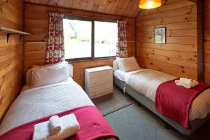 a bedroom with two beds in a log cabin at Retro Inn 2 - Lake Tekapo in Lake Tekapo