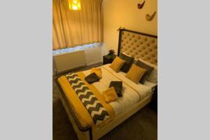 a bedroom with a bed with yellow and black pillows at Large 4 Bedroom House in Central Coventry in Walsgrave on Sowe