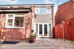 Large 4 Bedroom House in Central Coventry في Walsgrave on Sowe: منزل من الطوب مع باب وفناء