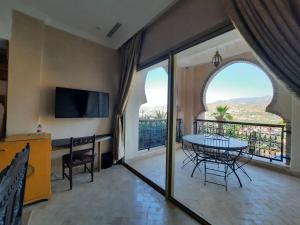 uma sala de estar com uma mesa e uma varanda em Borj Des Cascades & Spa em Ouzoud