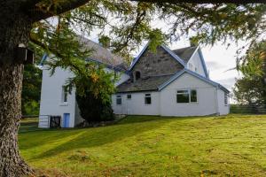 a white house with a tree in front of it at Alvey House in Newtonmore
