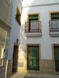 Edificio blanco con 2 balcones y 2 ventanas en CASA RURAL con Chimenea, Barbacoa, Terraza y Solarium, en Illar