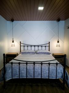 a bedroom with a black bed with two lights at Casa dos Trenós in Sabugueiro