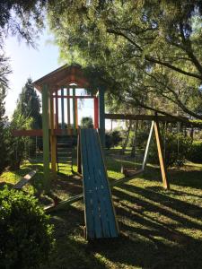 a playground with a slide and a play house at POUSADA DAS PIPAS in Vacaria