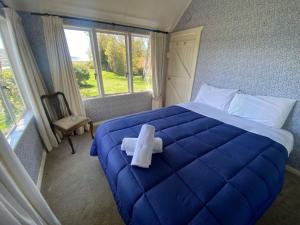 a room with a blue bed with a cross on it at Garden Cottage - Lake Tekapo in Lake Tekapo