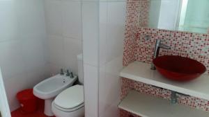 a bathroom with a toilet and a sink at Brisas 1 in Santa Teresita +6 photos