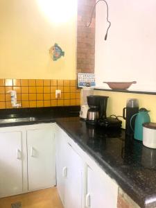 a kitchen with white cabinets and a black counter top at Casa Bromélia Green in Itacaré