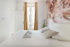 Un dormitorio con una cama blanca con toallas. en Rent a Room - Studio Bonne Nouvelle, en París