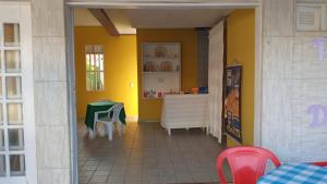 a dining room with a table and a yellow wall at Pousada Solar di Poletti in Nísia Floresta
