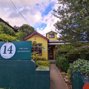 a yellow house with a sign in front of it at No14 Lovel St in Katoomba