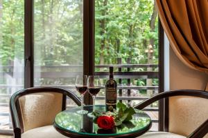 a table with two glasses of wine and a rose at Rediu Hotel & Restaurant in Botoşani