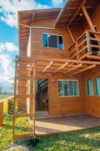 a tree house with a deck and a staircase at Recanto do Mar in Balneário Gaivotas +34 photos
