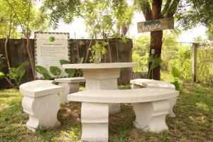 two white benches and a table in a park at Hotel Vista Verde in Huichihuayán