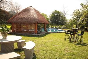 un cenador con mesas y sillas junto a una piscina en Hotel Vista Verde, en Huichihuayán